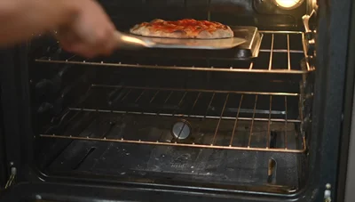 The baking tray method yields a pizza with good crispness, comparable to the pizza stone, but not as good as the baking steel.