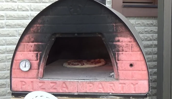 Cook the pizza. Monitor the bottom of the pizza to ensure it is cooking evenly.