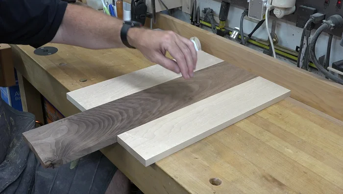 Laminate the wood: Joint all edges of the Maple and Walnut pieces to ensure a flush fit. Glue and clamp the pieces together using dowel joinery for alignment and added strength. Use Type III waterproof glue.