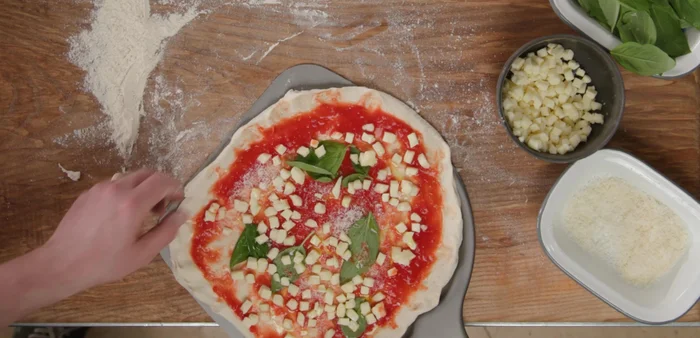 Slide the pizza onto the hot surface of the oven, using the back of the oven as a support until it catches.