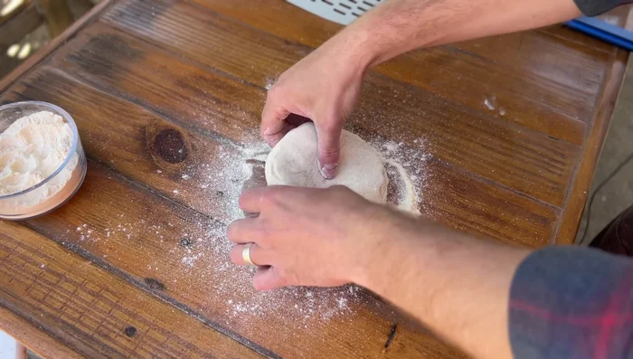 Season the dough: Generously dust the dough with the flour and cornmeal mixture, focusing on all surfaces. Pat it on gently rather than rubbing it in.