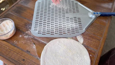 Shake test: Gently lift the peel and shake it to check if the dough is sticking. If it moves freely, you’re good to go. Add more flour/cornmeal if needed.