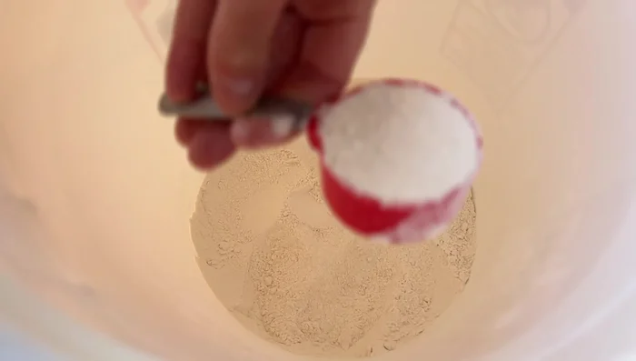 Prepare the flour and cornmeal mixture: Mix three parts flour and one part cornmeal. The speaker uses two scoops of the flour mixture and one scoop of cornmeal.