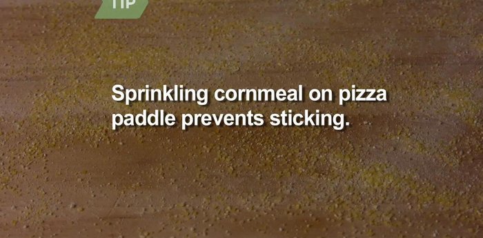 Put the dough, sauce, and toppings on top of the cornmeal on the paddle.