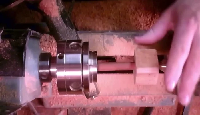 Mount the dowel pins in the lathe chuck. Turn them down to create the handle knobs.