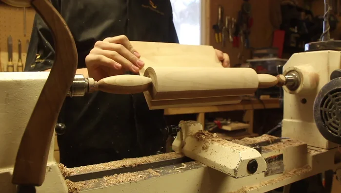 Sand the rolling pin using sandpaper on plywood to ensure a flat surface.