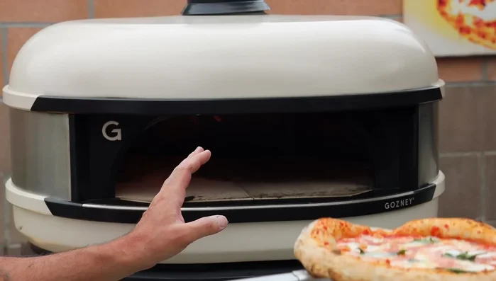 For subsequent pizzas, keep the oven at max heat. The residual heat is sufficient for excellent cooking. Following this 'pizza in, flame down' method will prevent the bottom from burning.