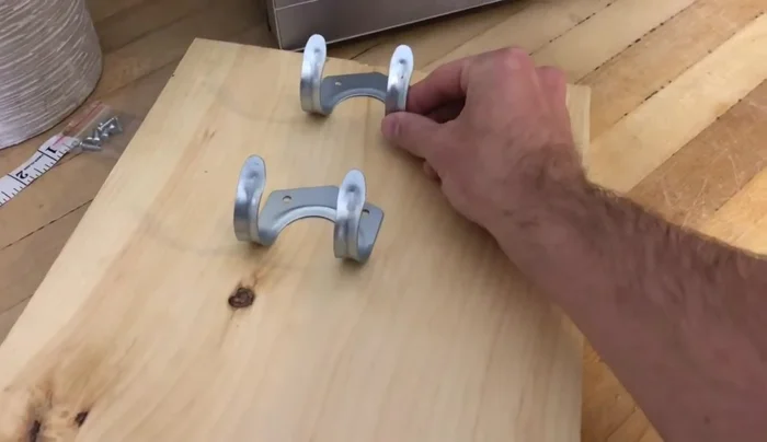 Secure the hooks: Attach the garage hooks to the pine board using the provided hardware. You can easily do this by hand if using pine.