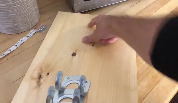 Mark the center of your pine board and then mark bracket positions: My brackets were 5 inches apart, but you might need to adjust this depending on your rolling pin sizes.