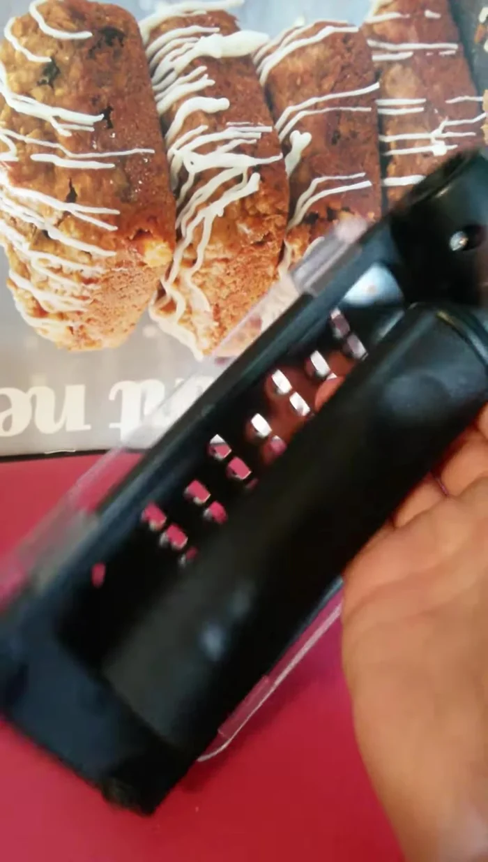 Squeeze the grater as if making a fist. You should hear a click indicating the unlock.