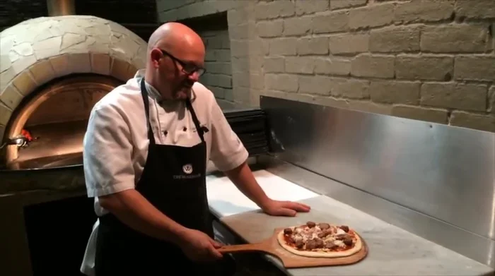 Add toppings (example: Wacky Meatball pizza with homemade BBQ sauce, Wagyu brisket, mozzarella).