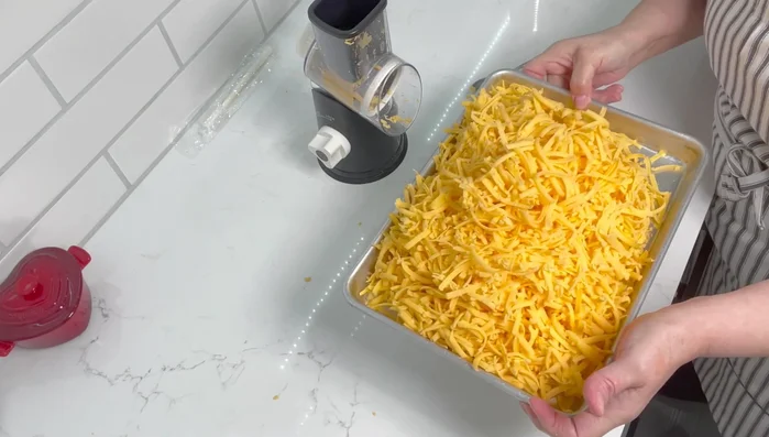 Remove the grated cheese from the grater. Store in freezer bags for later use.