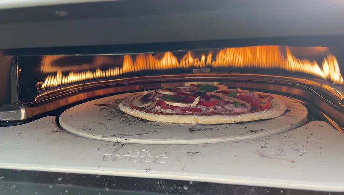 Pizza oven with rotating stone and U-shaped burner.