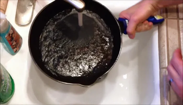 Rinse the pan with lukewarm water to remove loose food particles.