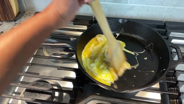 Eggs cooking effortlessly in cast iron skillet