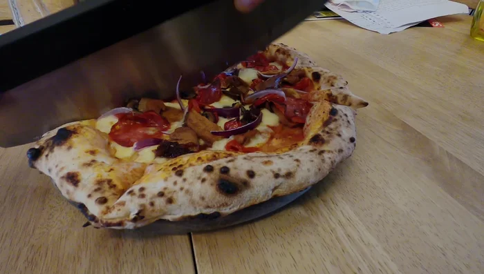 Ooni pizza cutter slicing pizza