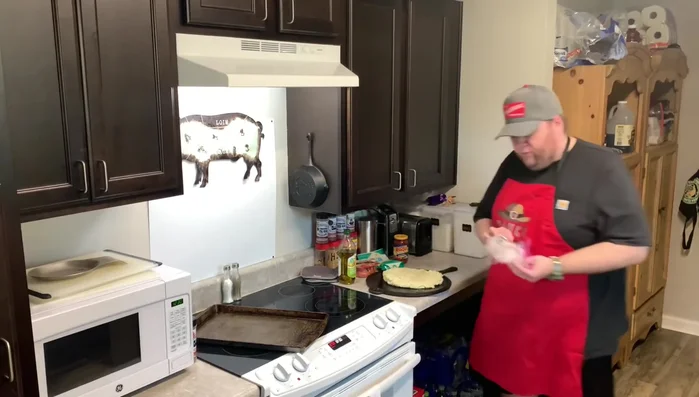 Man preparing pizza dough on pizza stone.