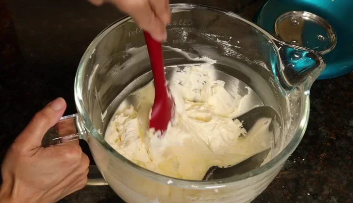 Unmixed batter in a mixing bowl, needs scraping.