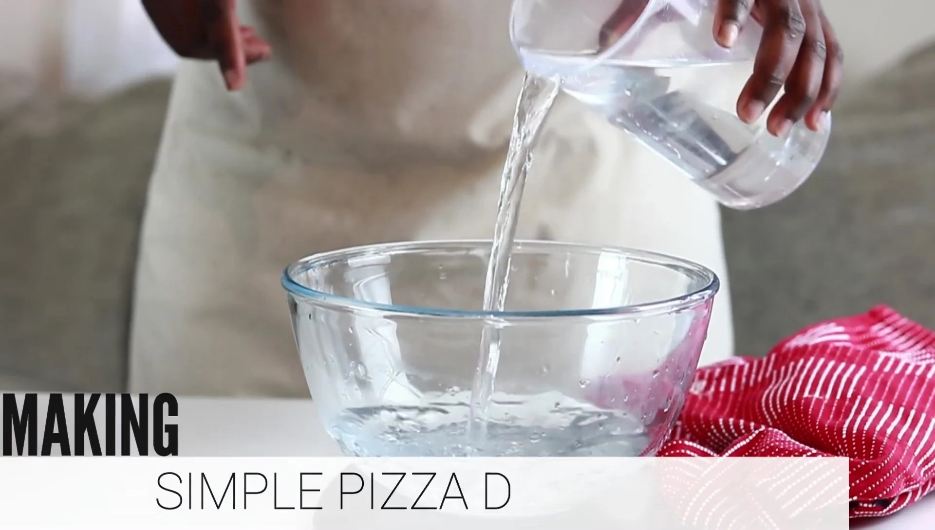 Making pizza dough: adding water to bowl