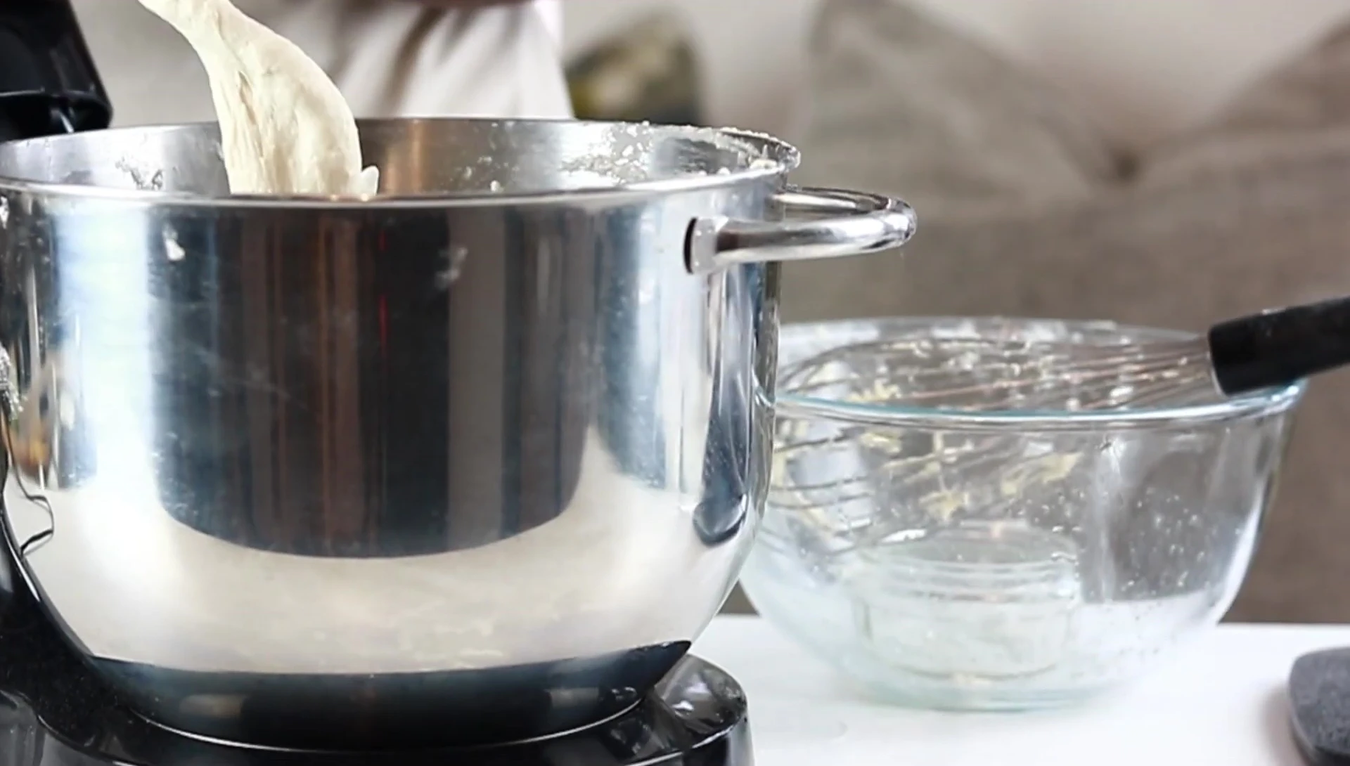 Hand-mixing pizza dough in a stand mixer.