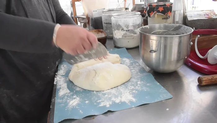 Cutting pizza dough into portions.