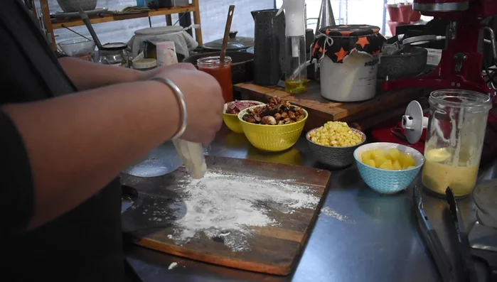 Preparing pizza dough on a cutting board.