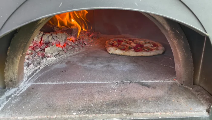 Maintain the pizza in one spot to avoid uneven cooking. If necessary, add additional wood to sustain the flame and convection heat.