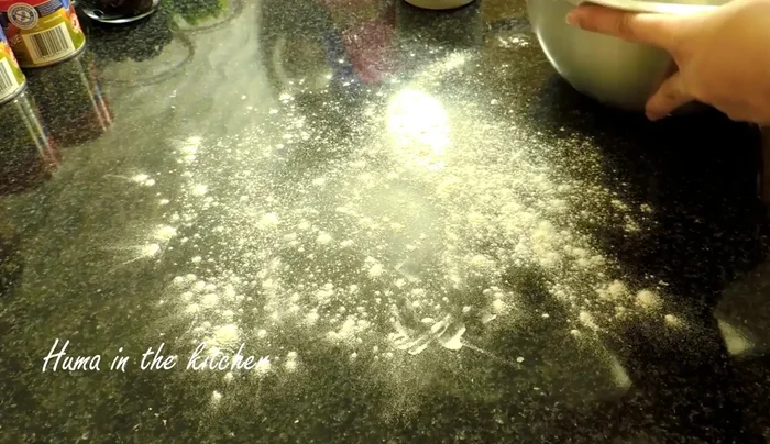 Prepare the pizza base: Divide the risen dough into portions. Roll or stretch one portion into a circle to fit your pan.