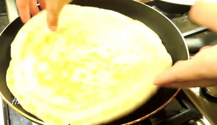 Add toppings: Brush the cooked side of the base with oil. Spread pizza sauce, mozzarella cheese, chicken, onion, capsicum, olives, and seasoning over the base.