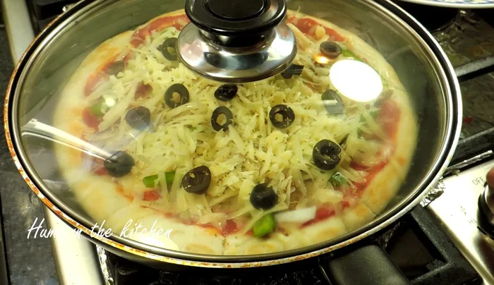 Bake the pizza: Cover the pan and cook on low-medium heat for 6-7 minutes, or until the cheese is melted.