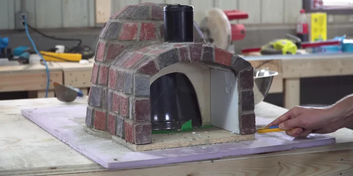 Remove the oven body from its mold and apply a layer of refractory cement to the interior.