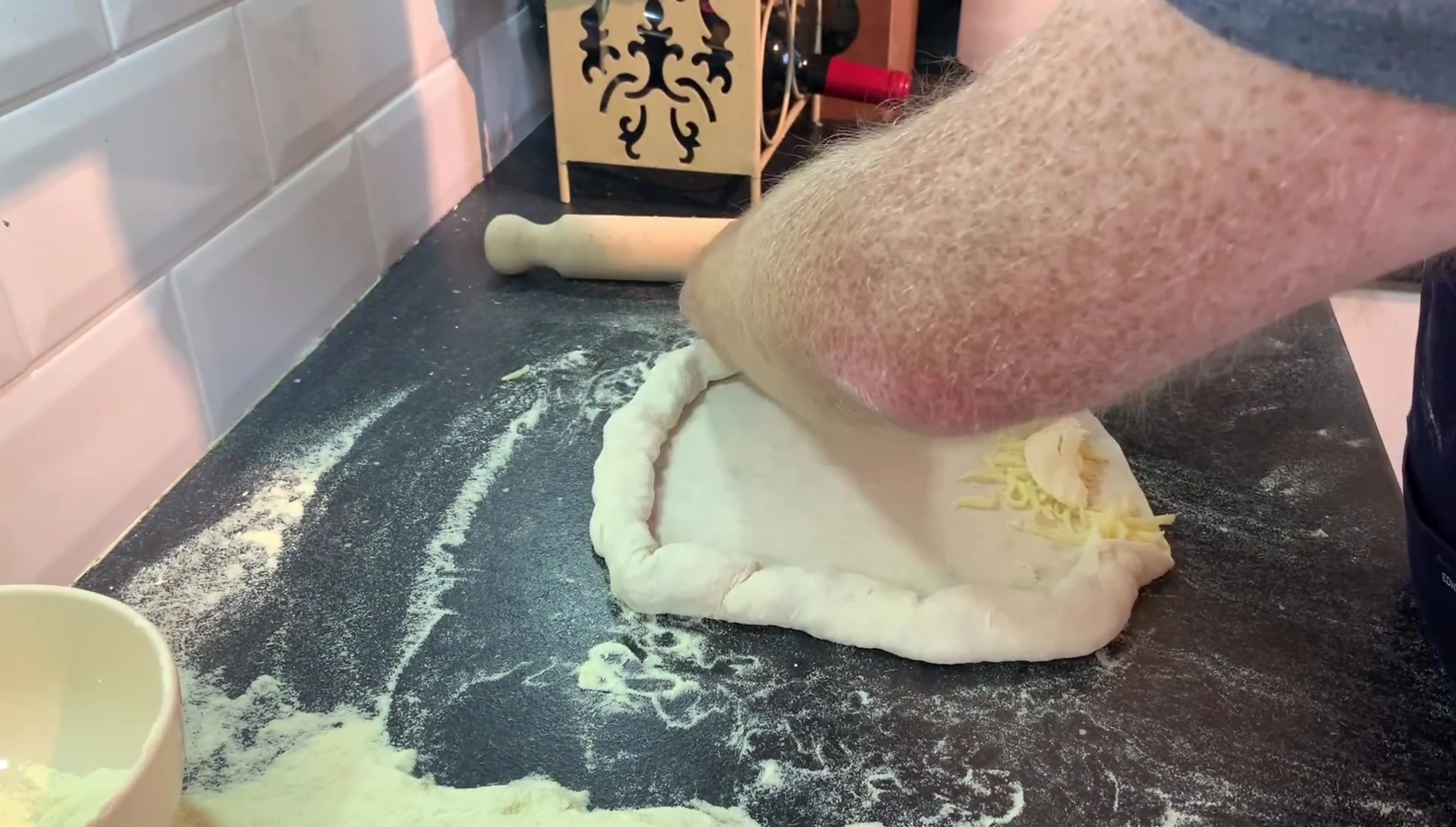 Folding dough over cheese filling for calzone.