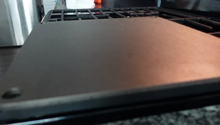 Apply a thin layer of canola oil to the pizza steel, covering the entire surface.