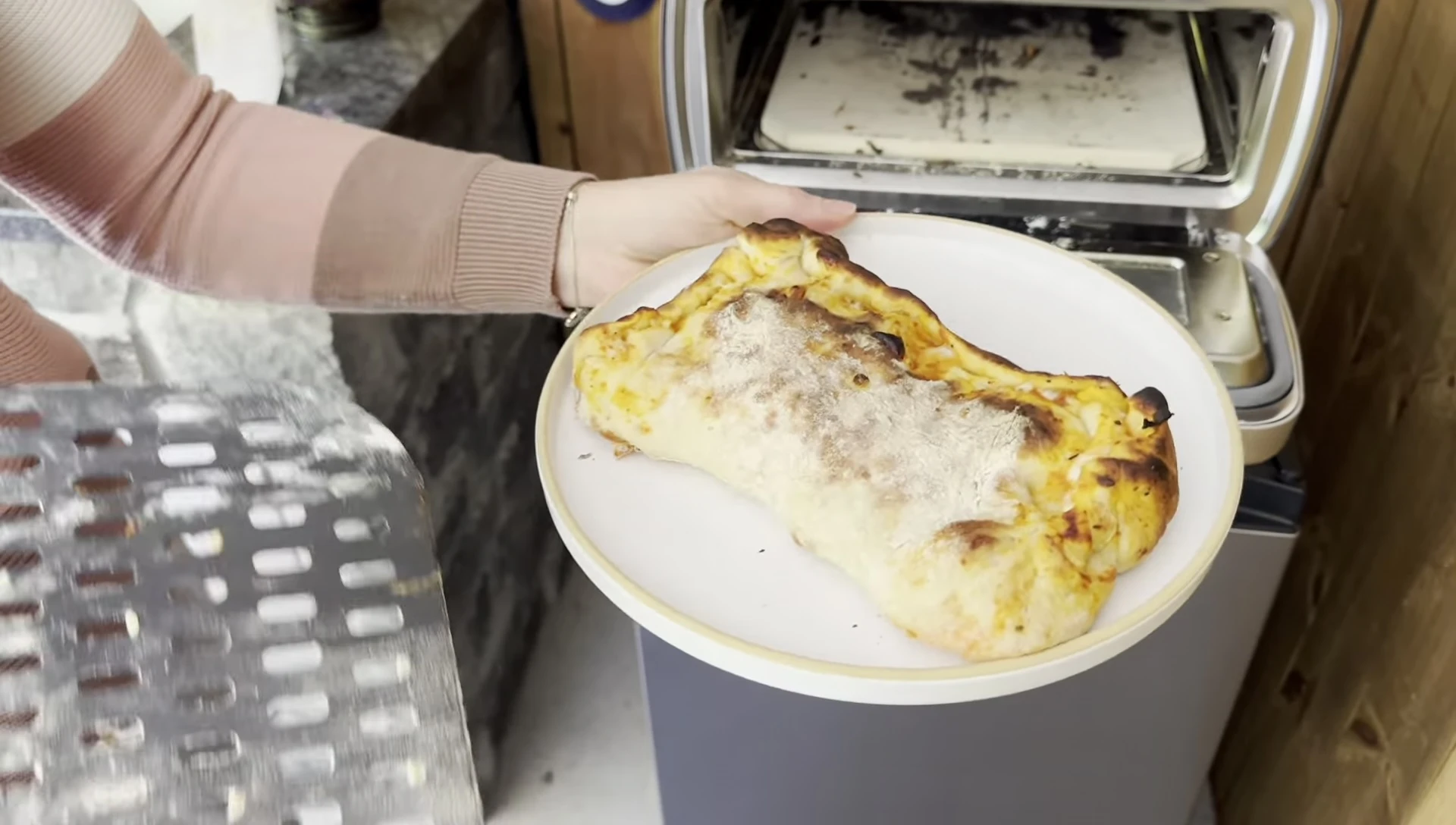The reviewer expressing her satisfaction with the cooked calzone.