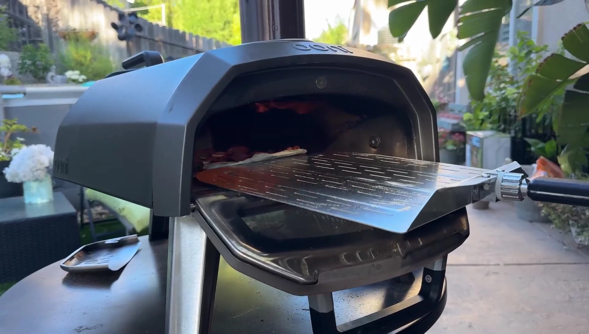 Using the pizza peel to shield the pizza from direct flames.