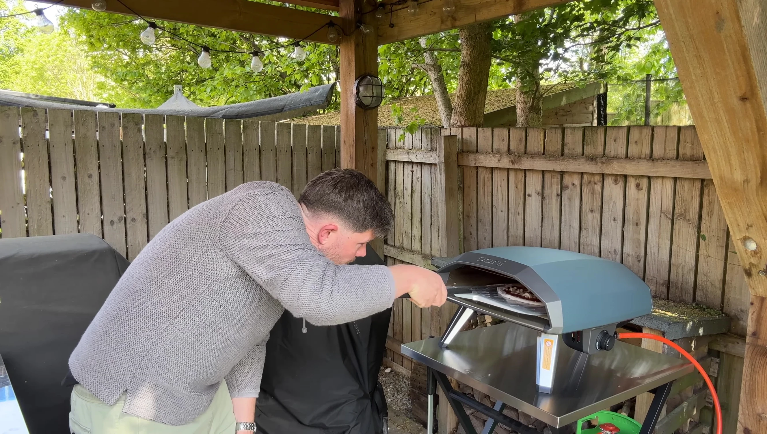 Placing the pizza inside the hot oven.