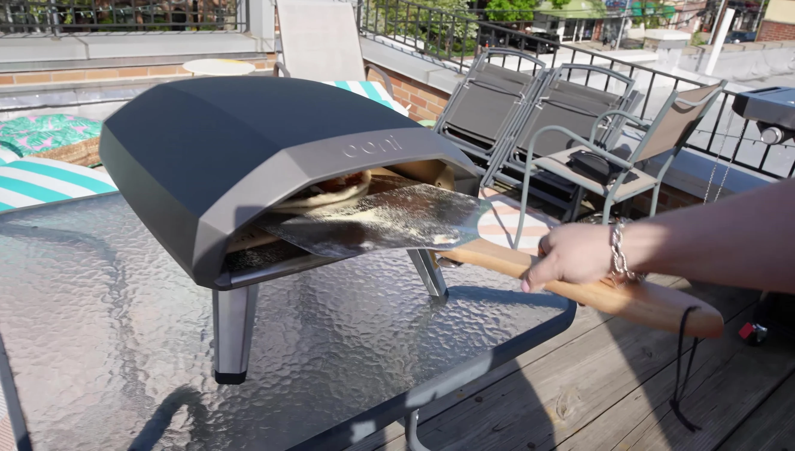 Person easily placing a pizza into the oven, emphasizing the 14-inch size and ease of use.
