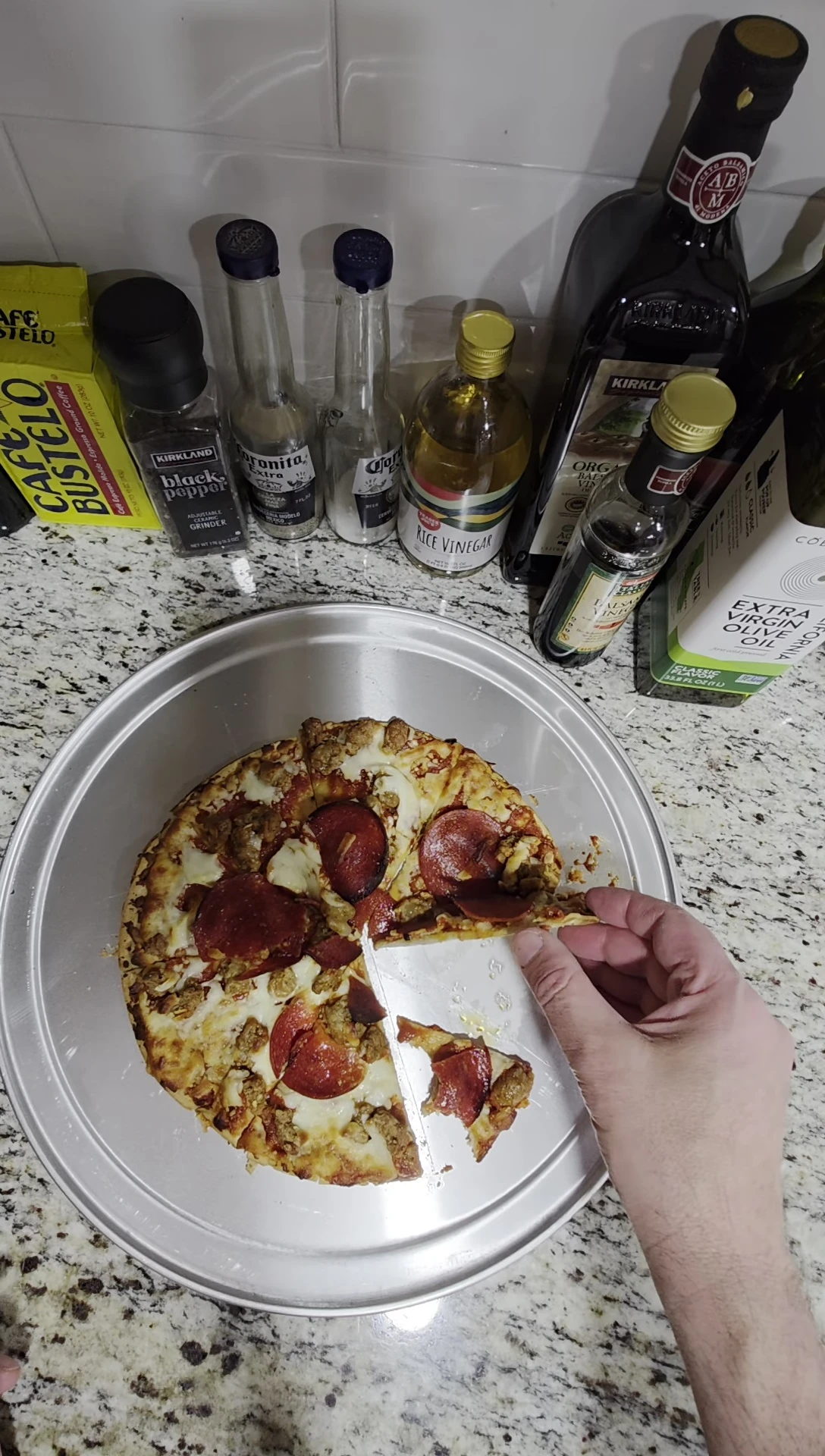 The reviewer holding a slice to highlight the crust.
