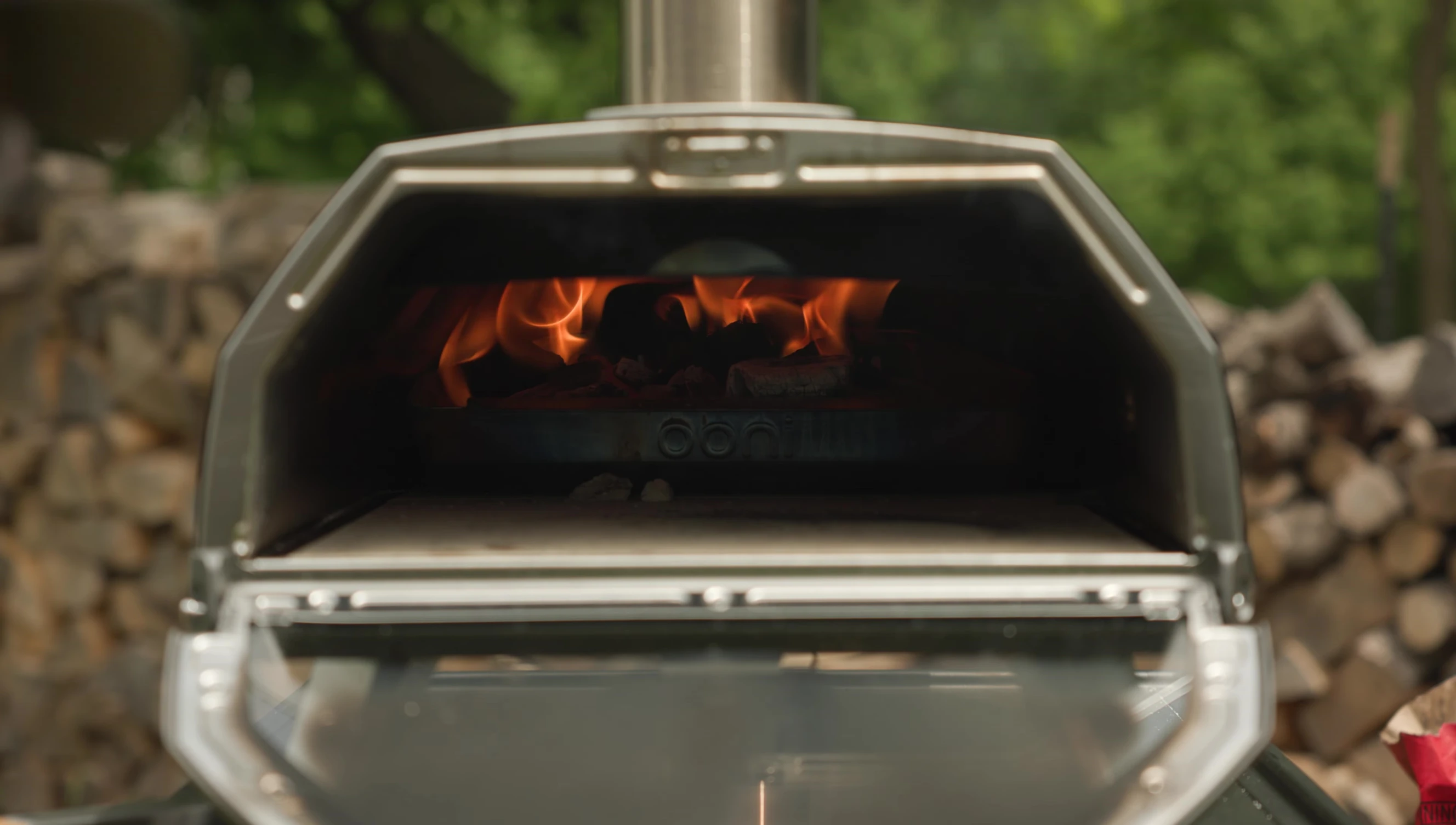 New York-style pizza baking with charcoal and wood