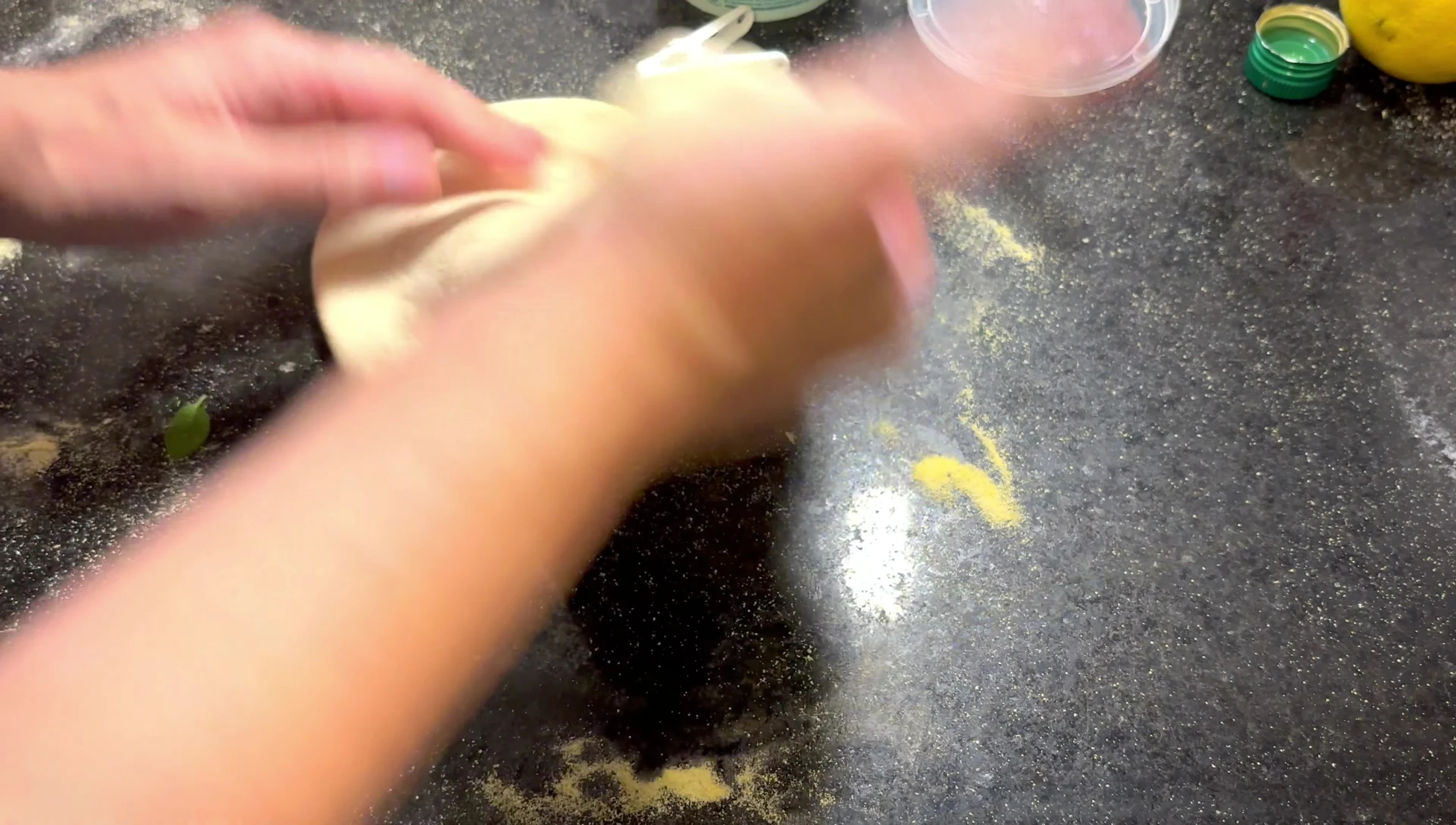 Dough being stretched with cornmeal