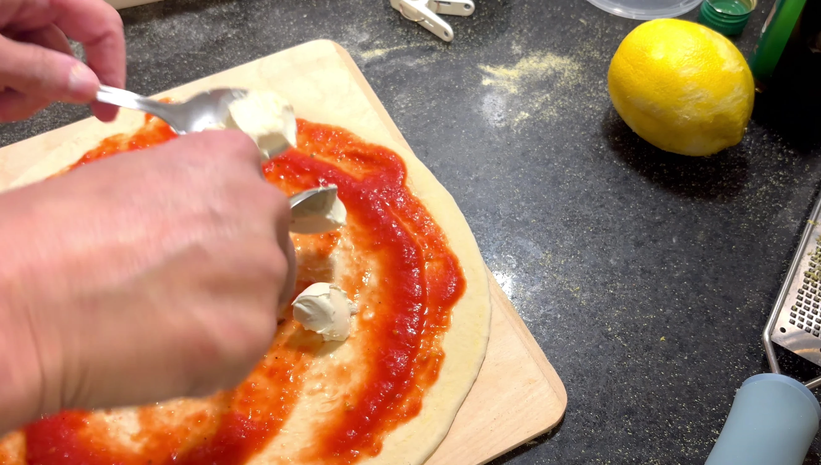 Pizza toppings being added