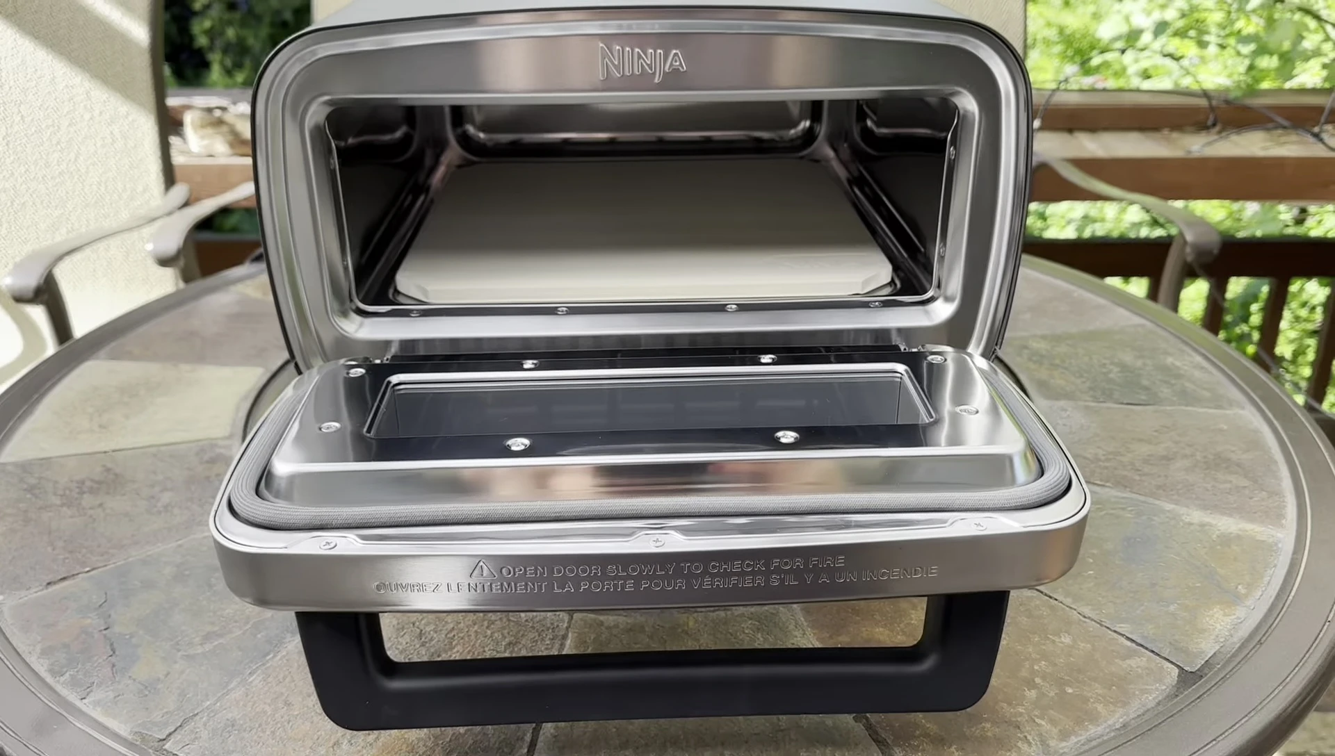 The oven with a pizza inside, highlighting the ease of use and no-rotation feature.