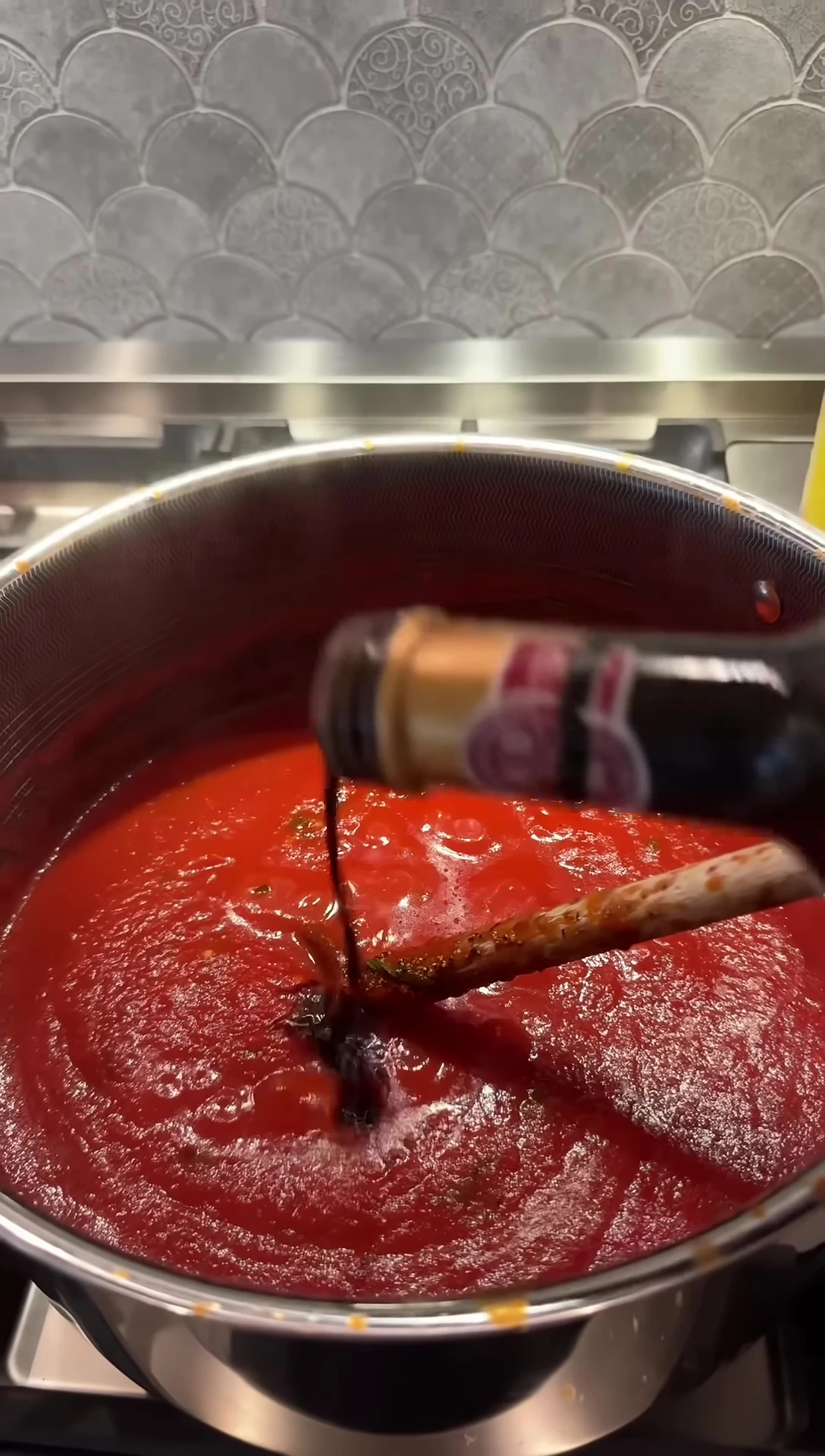 Adding balsamic vinegar as a final touch.