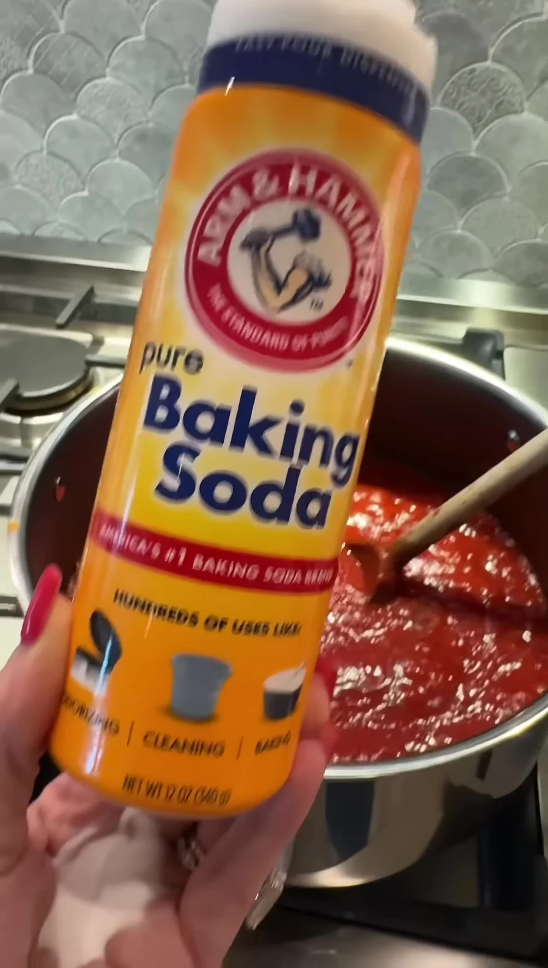 Adding baking soda to the boiling sauce.