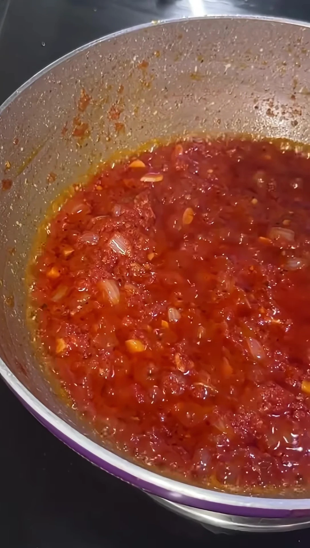 The sauce has thickened and released oil