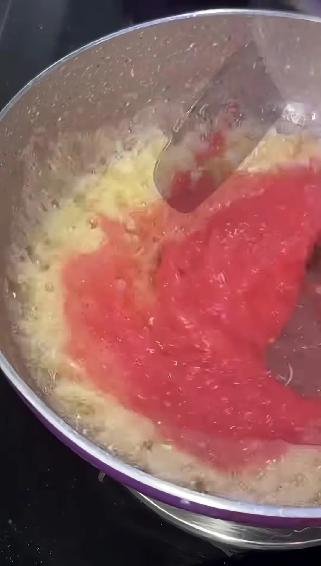 Adding tomato puree to the sautéed aromatics