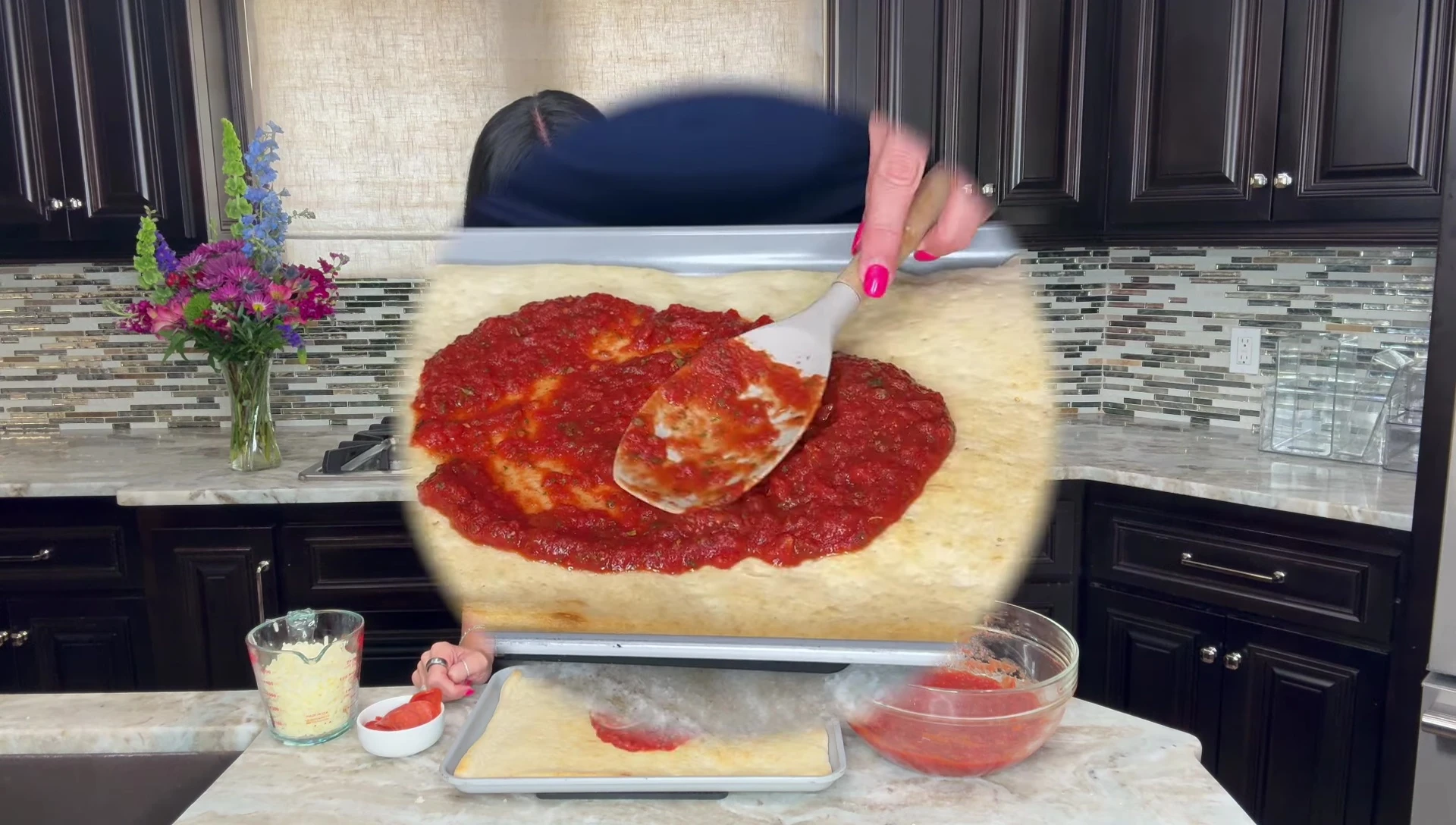 Applying sauce to the pizza base.