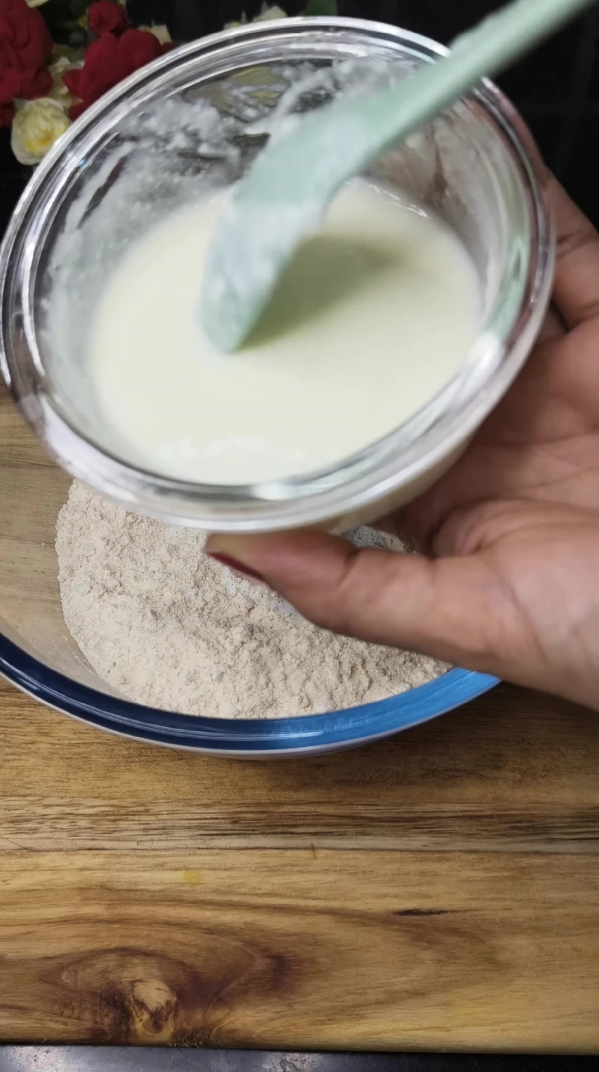 Adding fresh curd (yogurt) to the dough mixture.