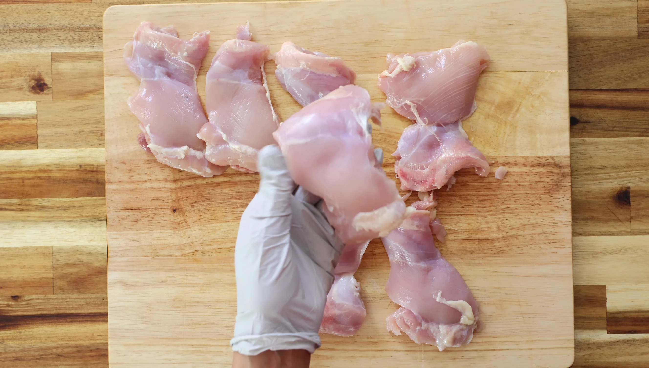 Slicing boneless, skinless chicken thighs