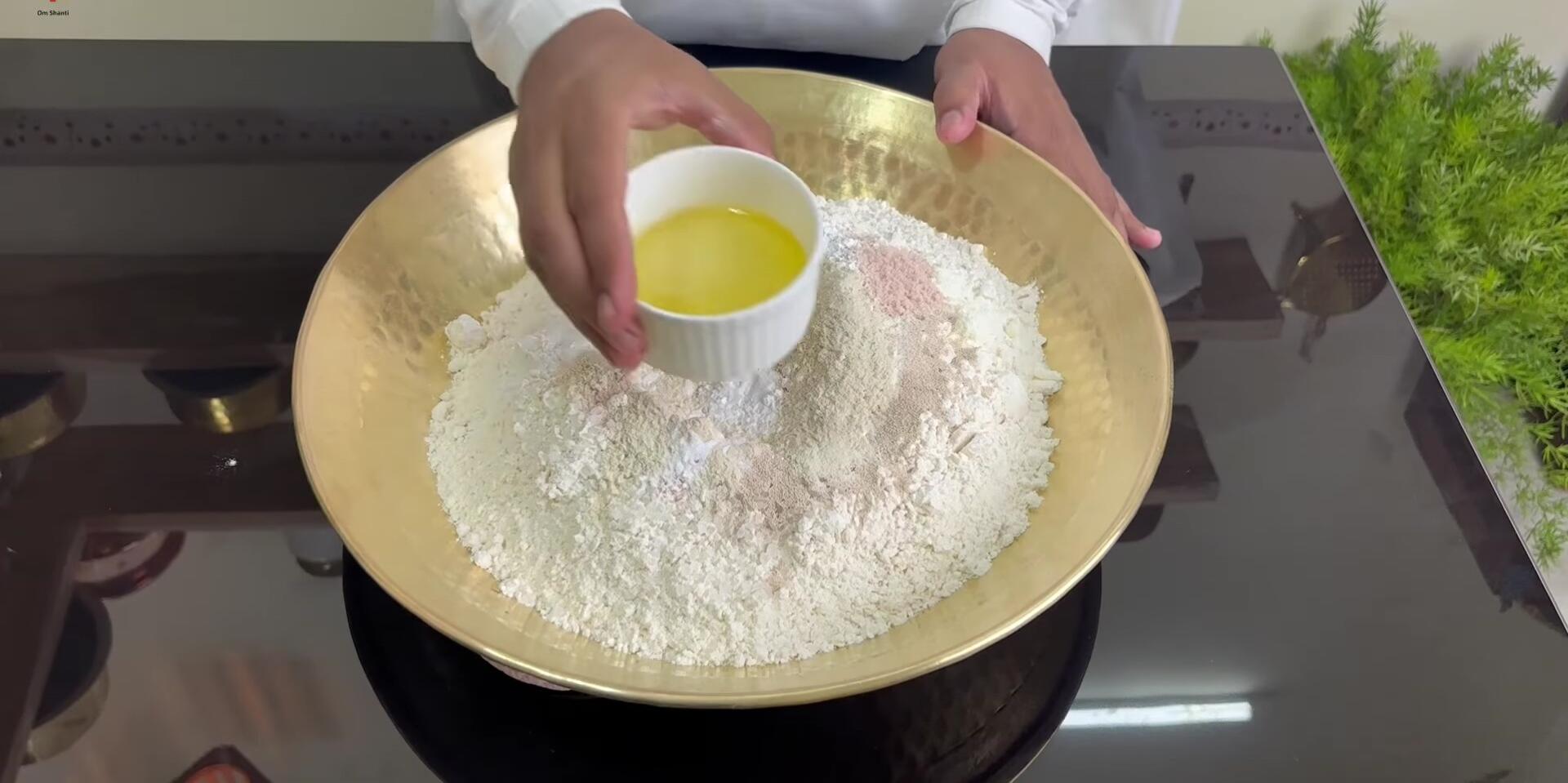Adding oil to the dough mixture.